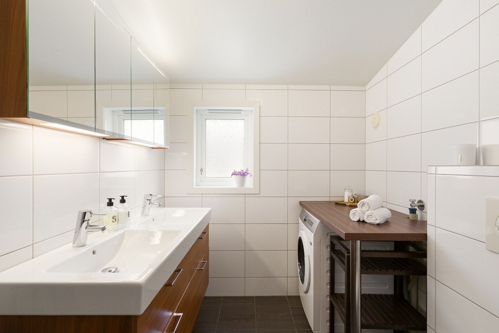 Badet er flislagt og innredet med romslig baderomsinnredning med dobbel servant og tilhørende speilskap. Galleribilde
