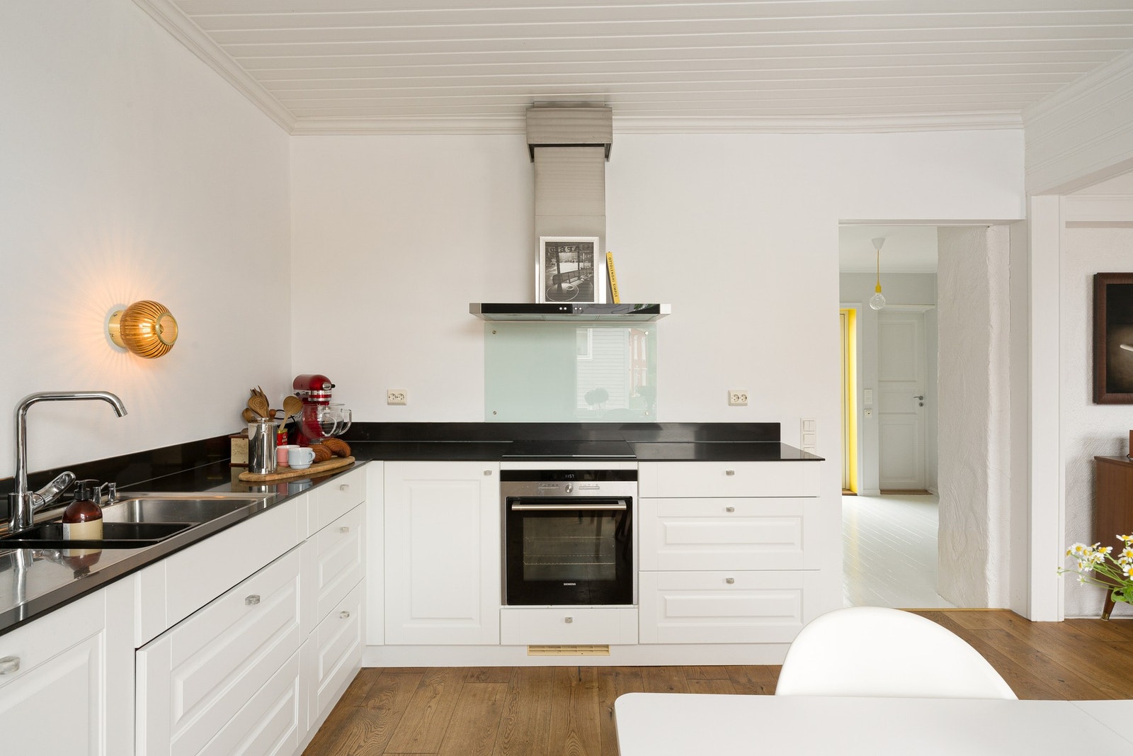 Kjøkkenet er utstyrt med integrerte hvitevarer som kjøl/fryseskap, oppvaskmaskin, induksjonstopp og stekeovn, samt ventilator med kullfilter. Galleribilde