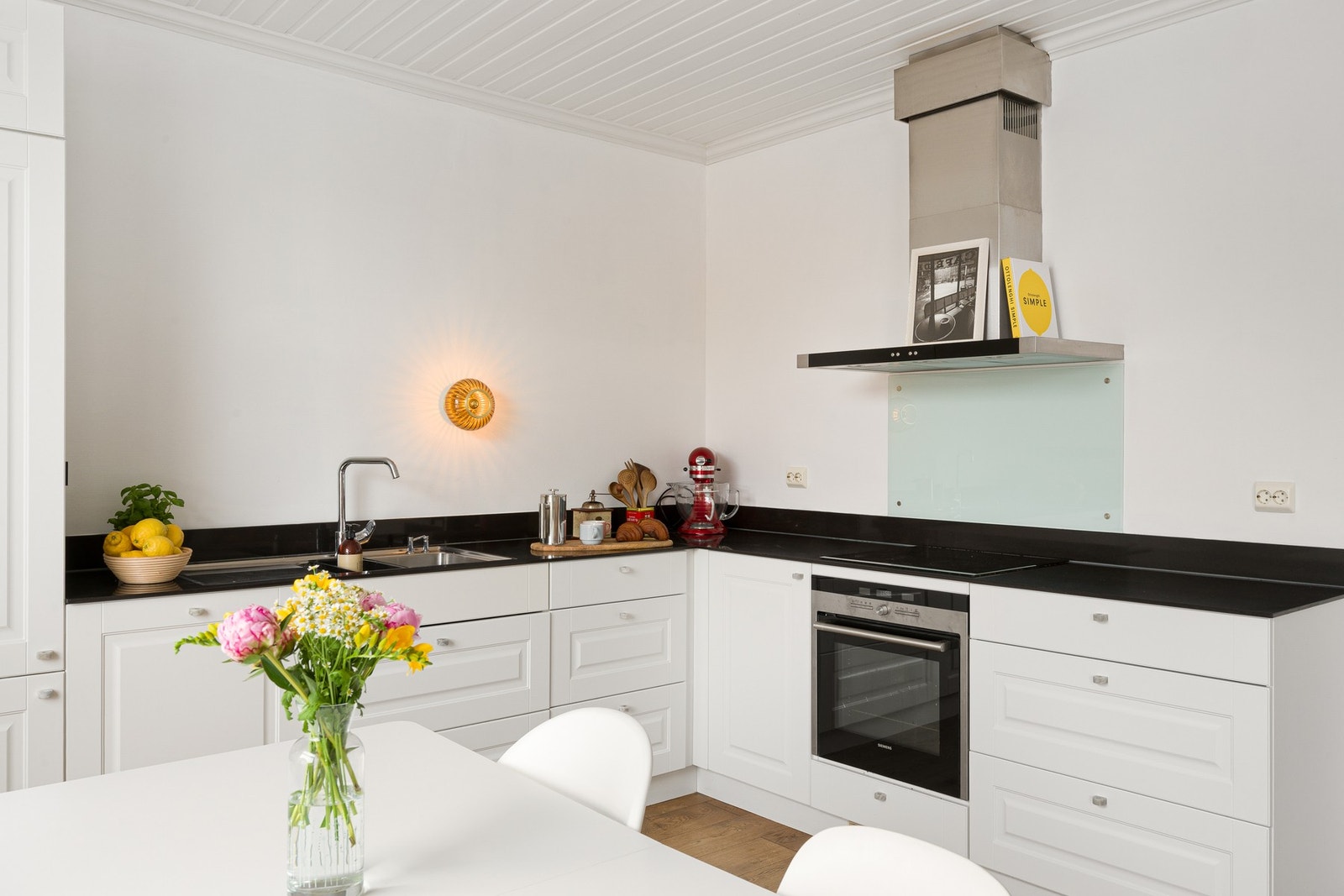 Innredningen har klassiske profilerte fronter i hvitt, godt med skapplass og mørk benkeplate som skaper en fin kontrast til de lyse overflatene og det varme tregulvet. Galleribilde