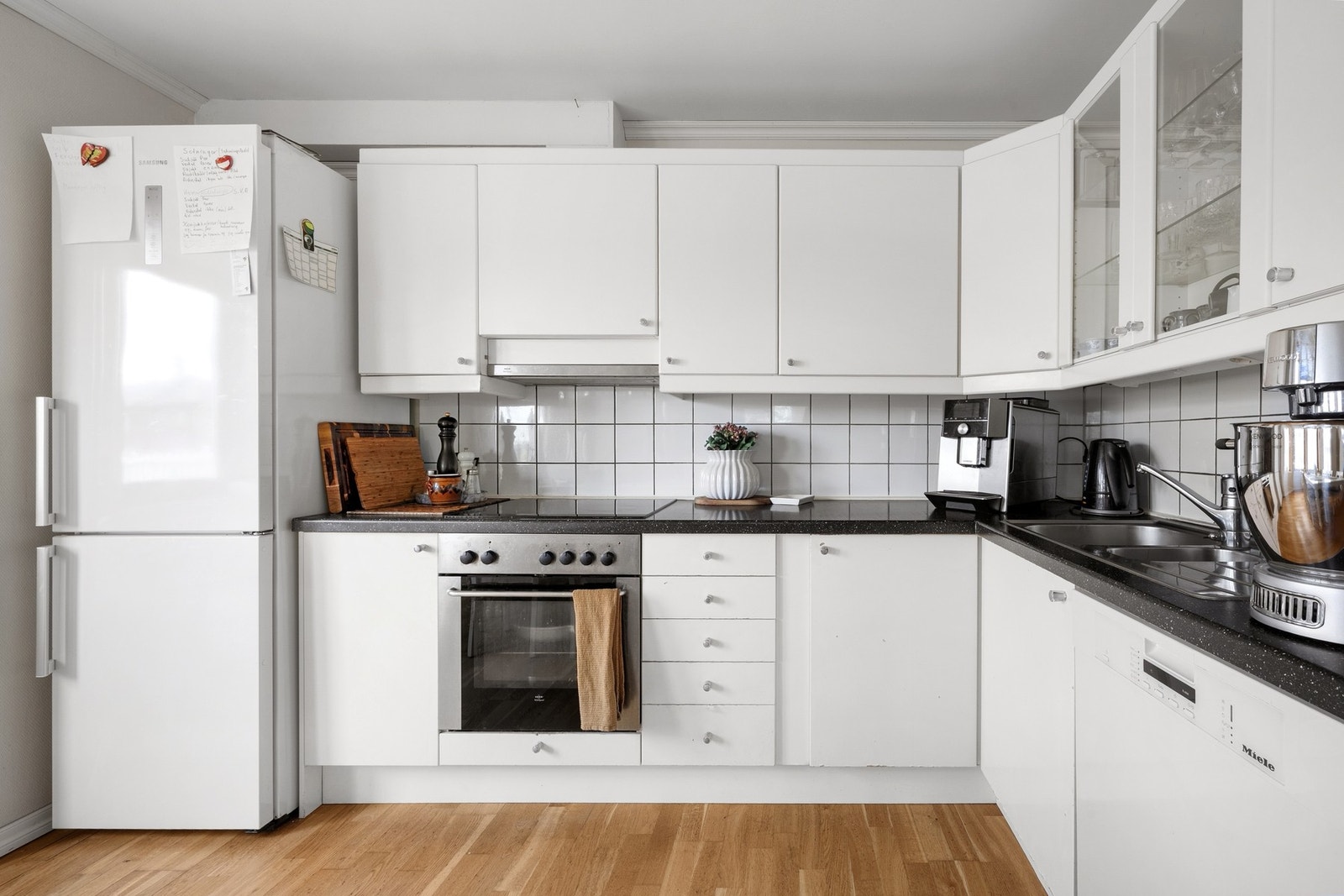 Kjøkkenet i underetasjen har innredning med hvite glatte fronter og benkeplate av laminat. Galleribilde