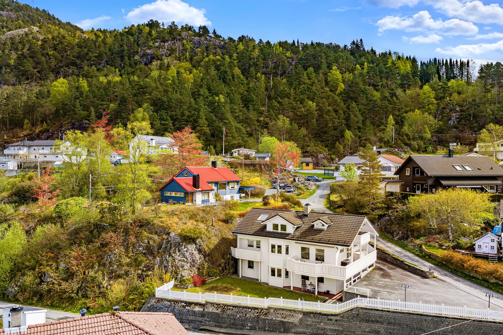 Tomten er fint opparbeidet med asfaltert tun og biloppstillingsplasser, murer, trapp, rekkverk, bed, beplantning, plen, grus og terrasse. Galleribilde