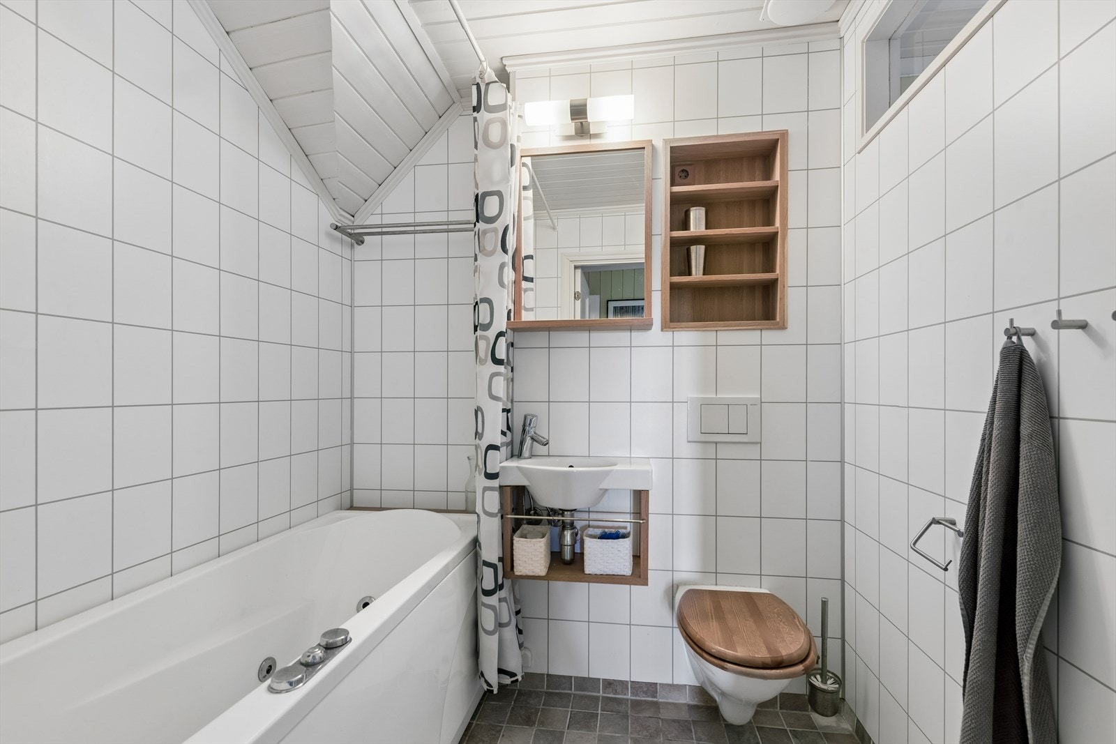 Badet i 2. etasje har innebygget toalett, liten porselensvask og boblebadekar med dusj garnityr. Galleribilde