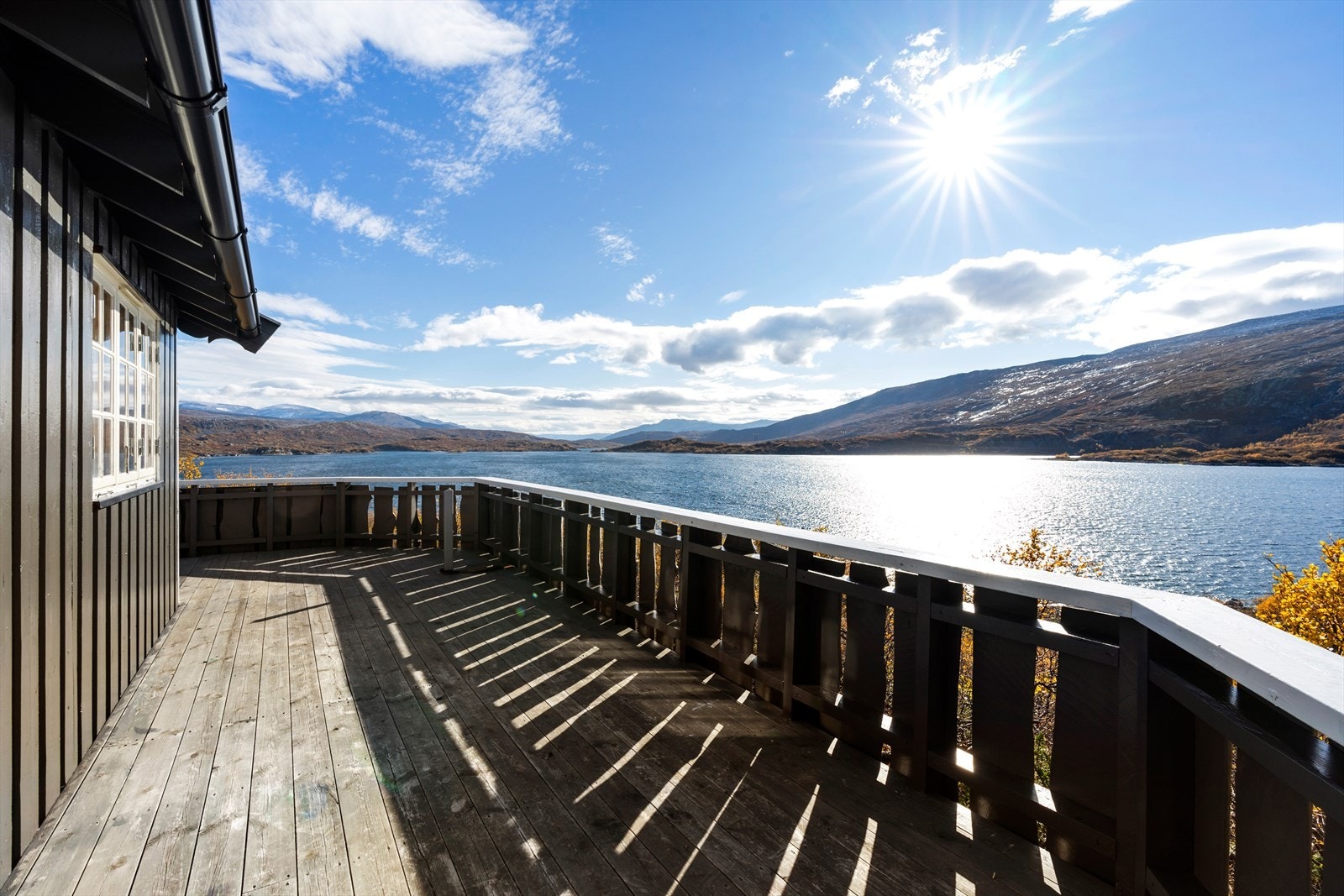 Utsikt fra terrassen gir panoramabilde av fjellandskap og vannet. Galleribilde
