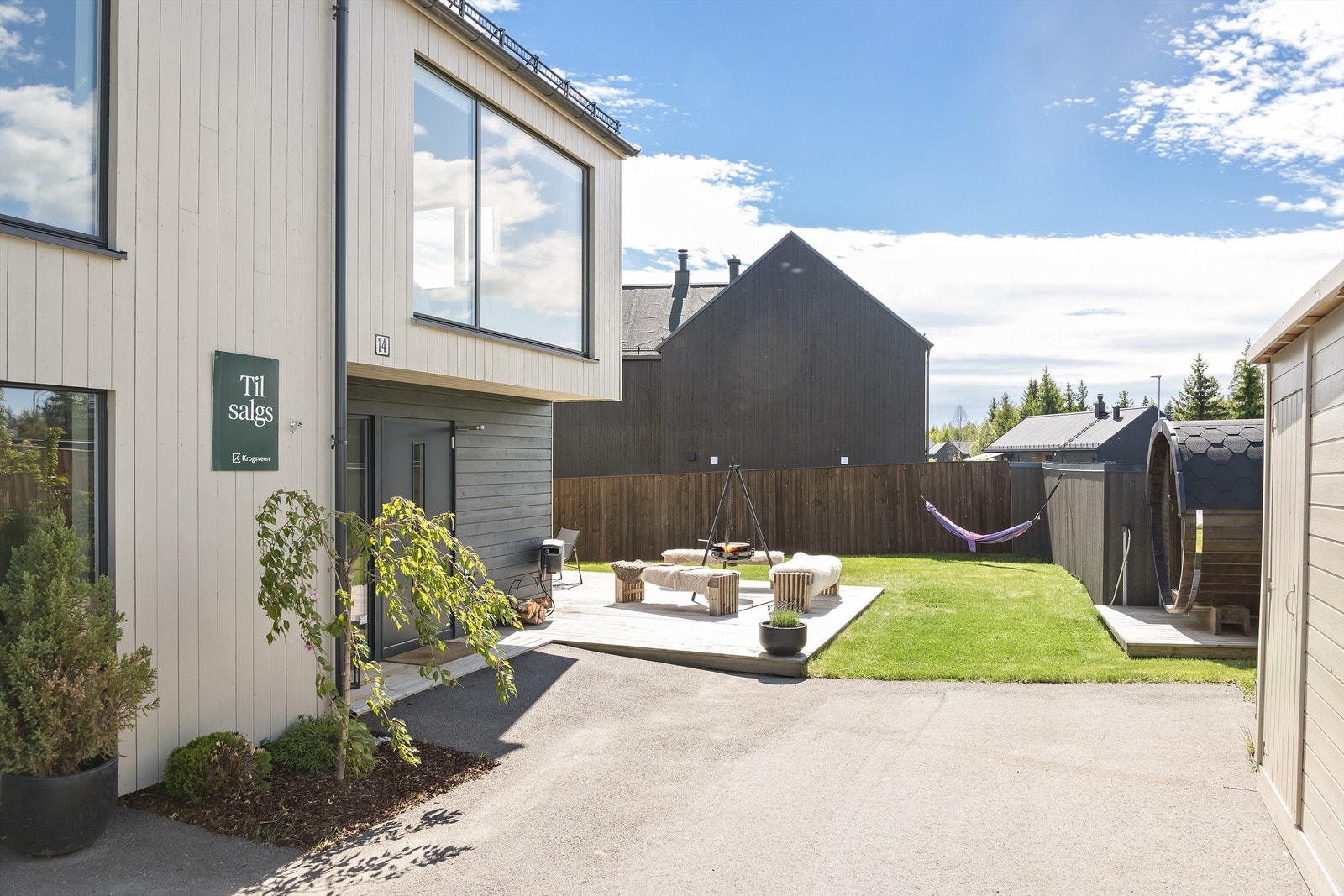Pent opparbeidet tomt med markterrasser, gressplen, badstue og vedbod. Galleribilde