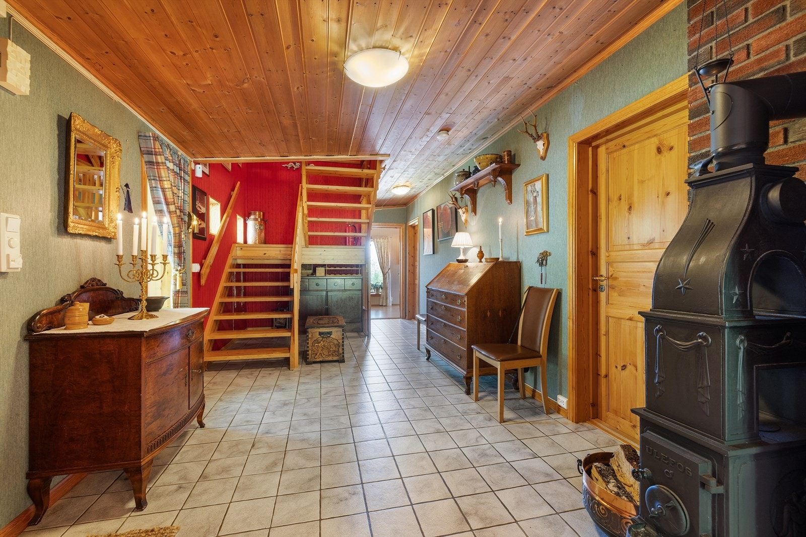 Hall med flislagt gulv og støpejernsovn. Galleribilde