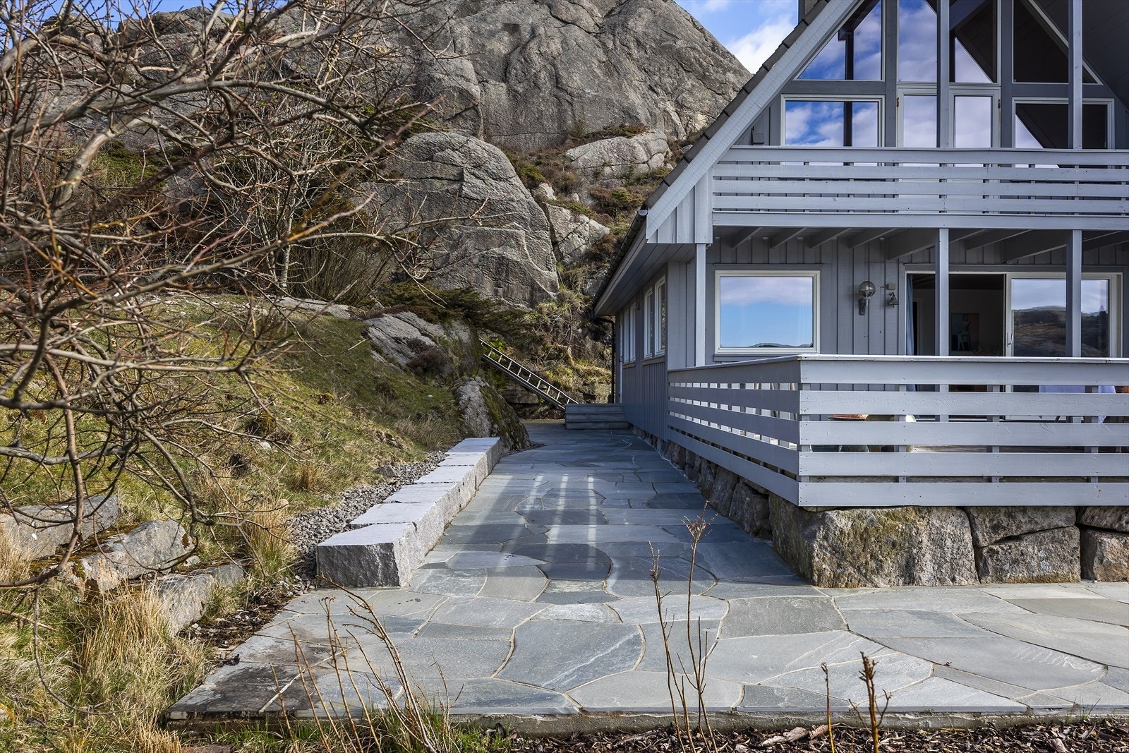 Terrenget rundt hytta er opparbeidet med bruddskifer og murer i naturstein. Galleribilde