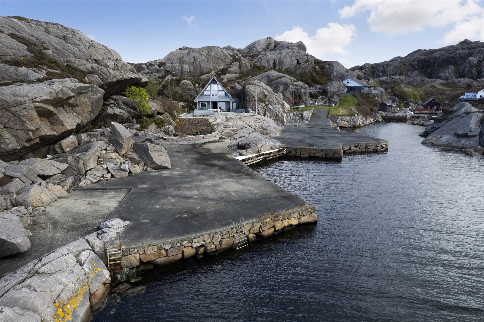 En flott frittliggende fritidseiendom med stor brygge, usjenert plassert i en lun vik i havgapet. Foto: Arne Ove Østebrøt Galleribilde