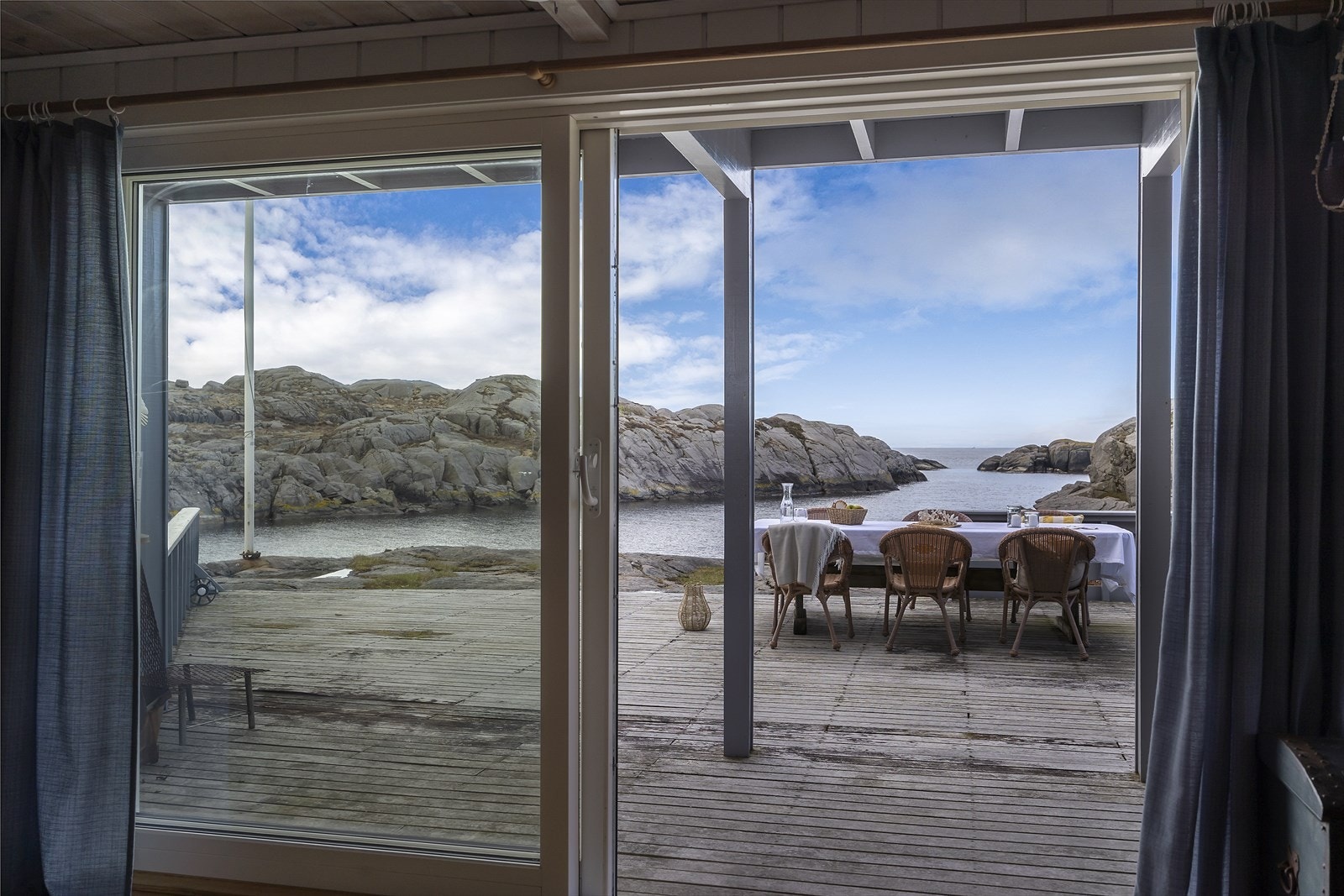 Skyvedøren i tre ble skiftet i 2018 og åpner opp mot terrassen og sjøutsikten. Galleribilde