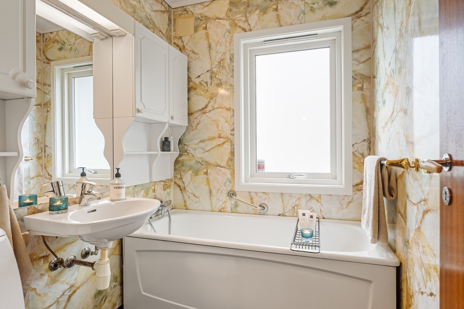 Badet inneholder servant, toalett og badekar. Veggene er kledd med våtromsplater, og gulvet har gulvbelegg. Det er naturlig avtrekk og sluk av plast. Badet har oppgraderingsbehov. Galleribilde