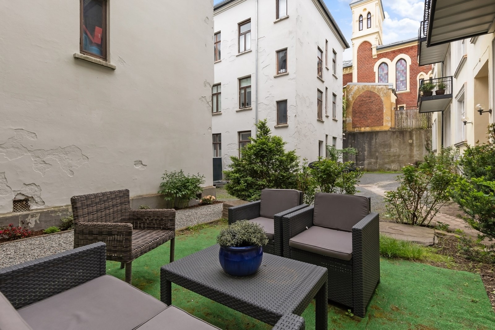 Hyggelig, skjermet bakgård og forhage opparbeidet med sittegrupper og beplantning. Galleribilde