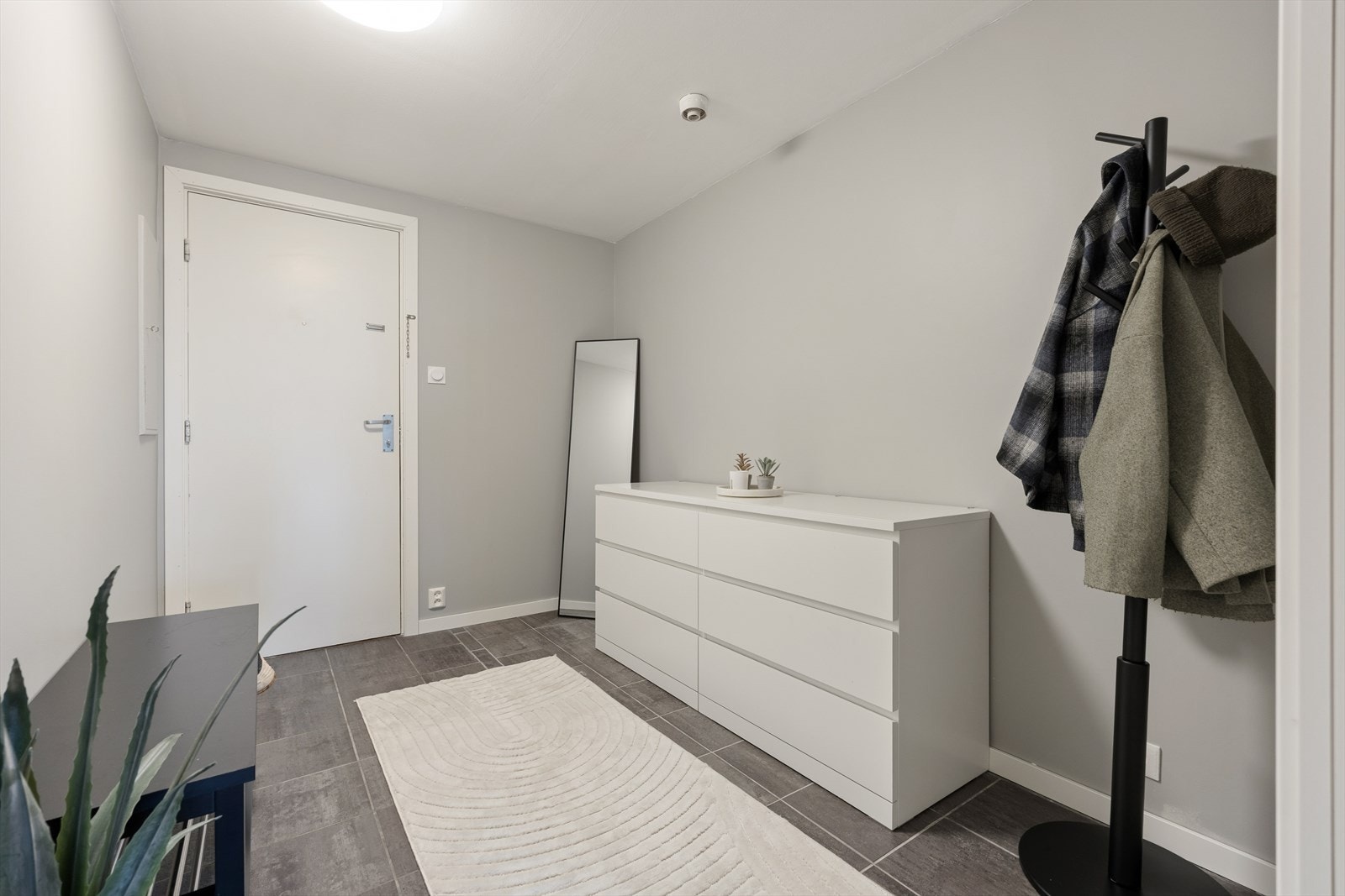 Entréen ønsker velkommen med nye fliser på gulvet fra 2023 og god plass til oppbevaring. Galleribilde