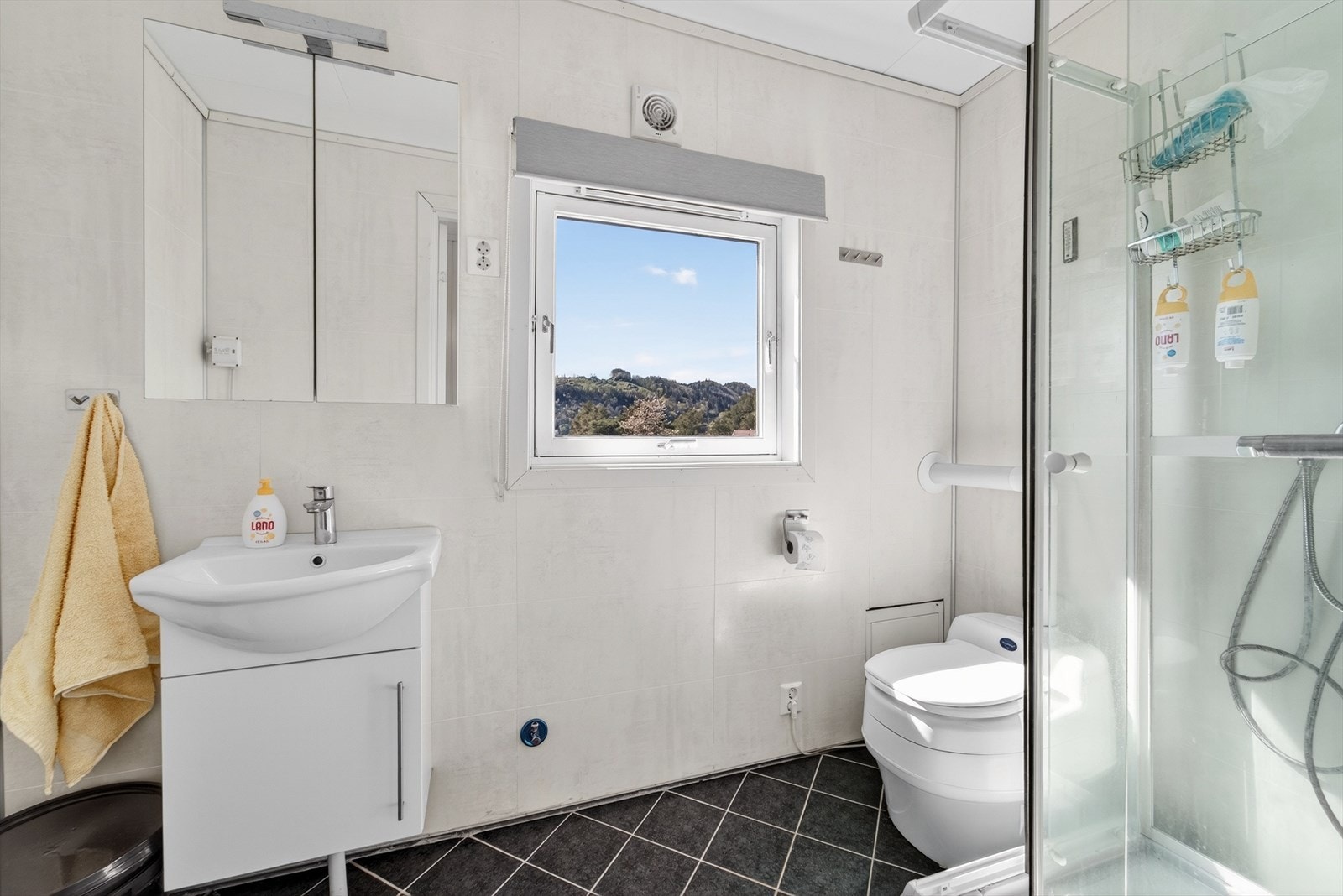 Badet i annekset har flislagt gulv med elektriske varmekabler, dusjkabinett og tørrtoalett fra Separett Galleribilde