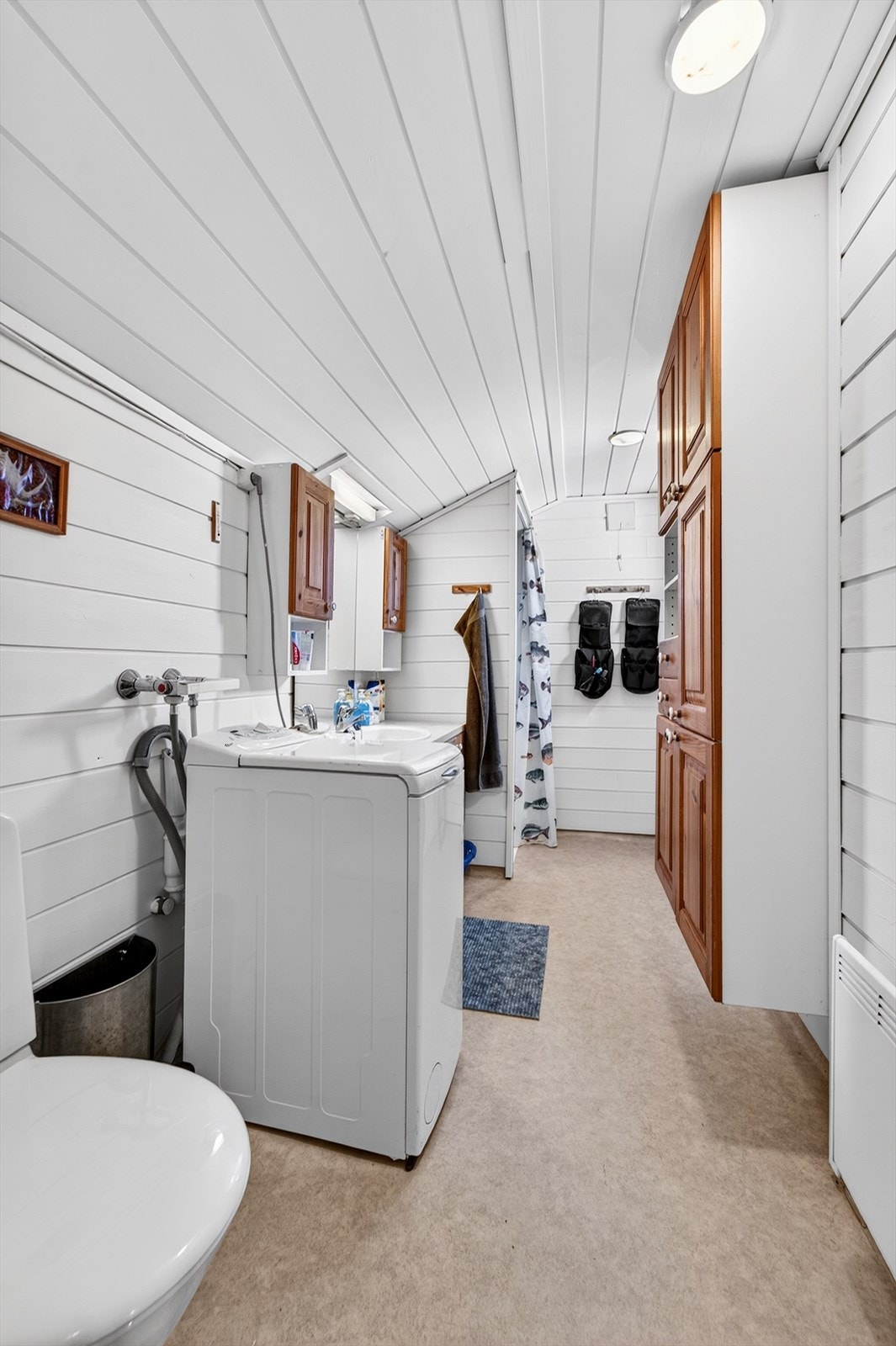 Badet i hovedhytta har vinylbelegg på gulv, dusjhjørne og opplegg for vaskemaskin. Galleribilde