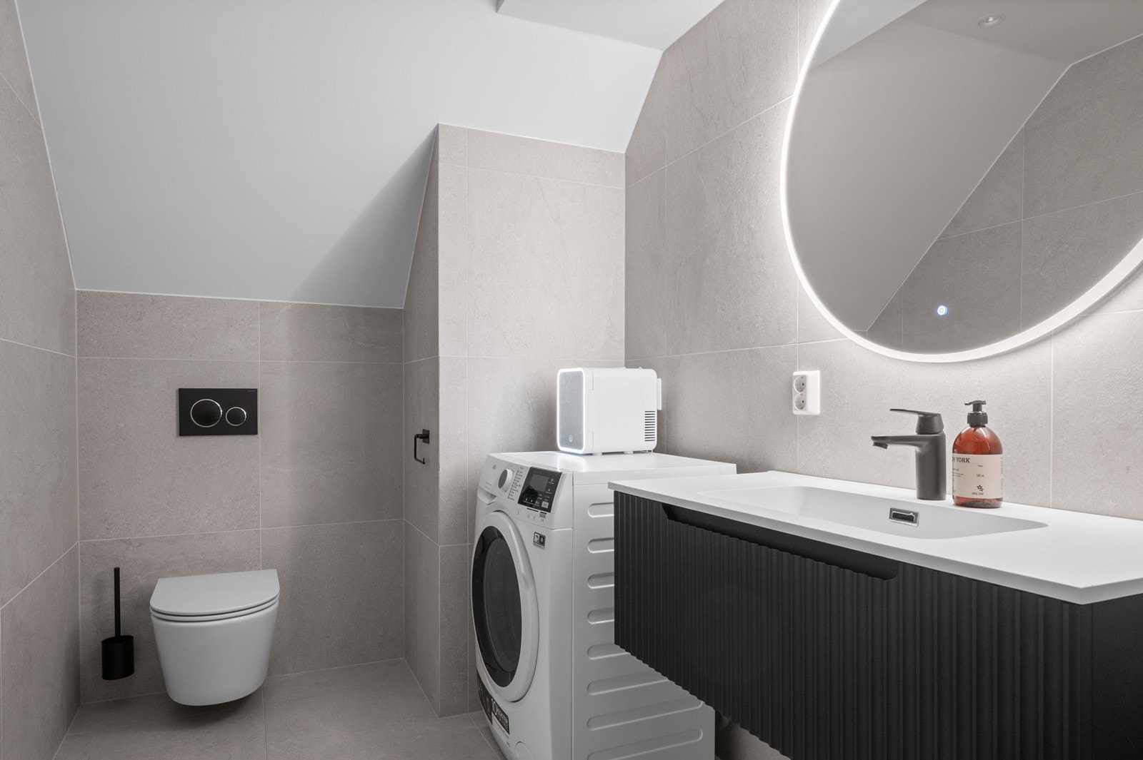 Badet er innredet med dusjnisje, servant med underskap og vegghengt toalett. Galleribilde