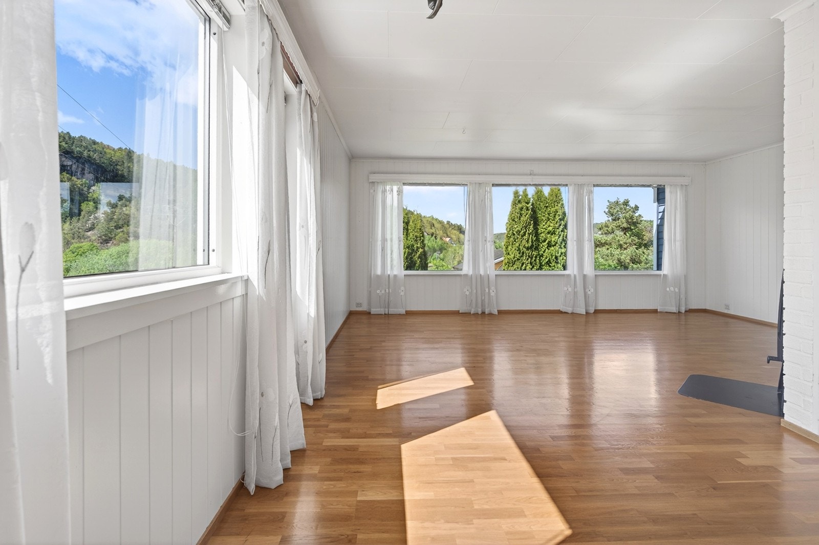 Lys stue med parkettgulv og malt panel Galleribilde