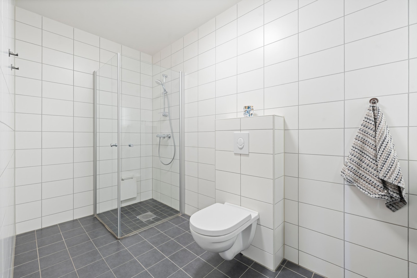 Delikat bad i underetasjen med stilrent dusjhjørne som gir badet et moderne og funksjonelt uttrykk. Tidløse flater og gjennomført design skaper en rolig og elegant atmosfære. Galleribilde