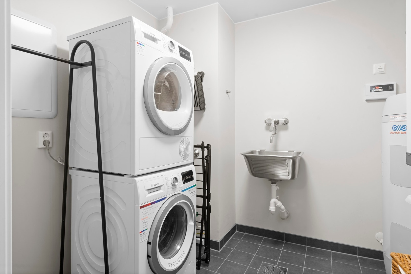 Praktisk teknisk rom med opplegg for vaskemaskin, tørketrommel og skyllekar, samt plass til boligens tekniske installasjoner. Et funksjonelt rom som gir god oversikt og orden i hverdagen. Galleribilde