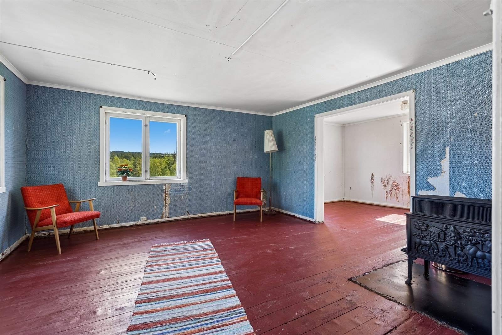 Stor stue med plass til både spisegruppe og sofakrok. Vedovn bidrar til oppvarming i boligen. Galleribilde