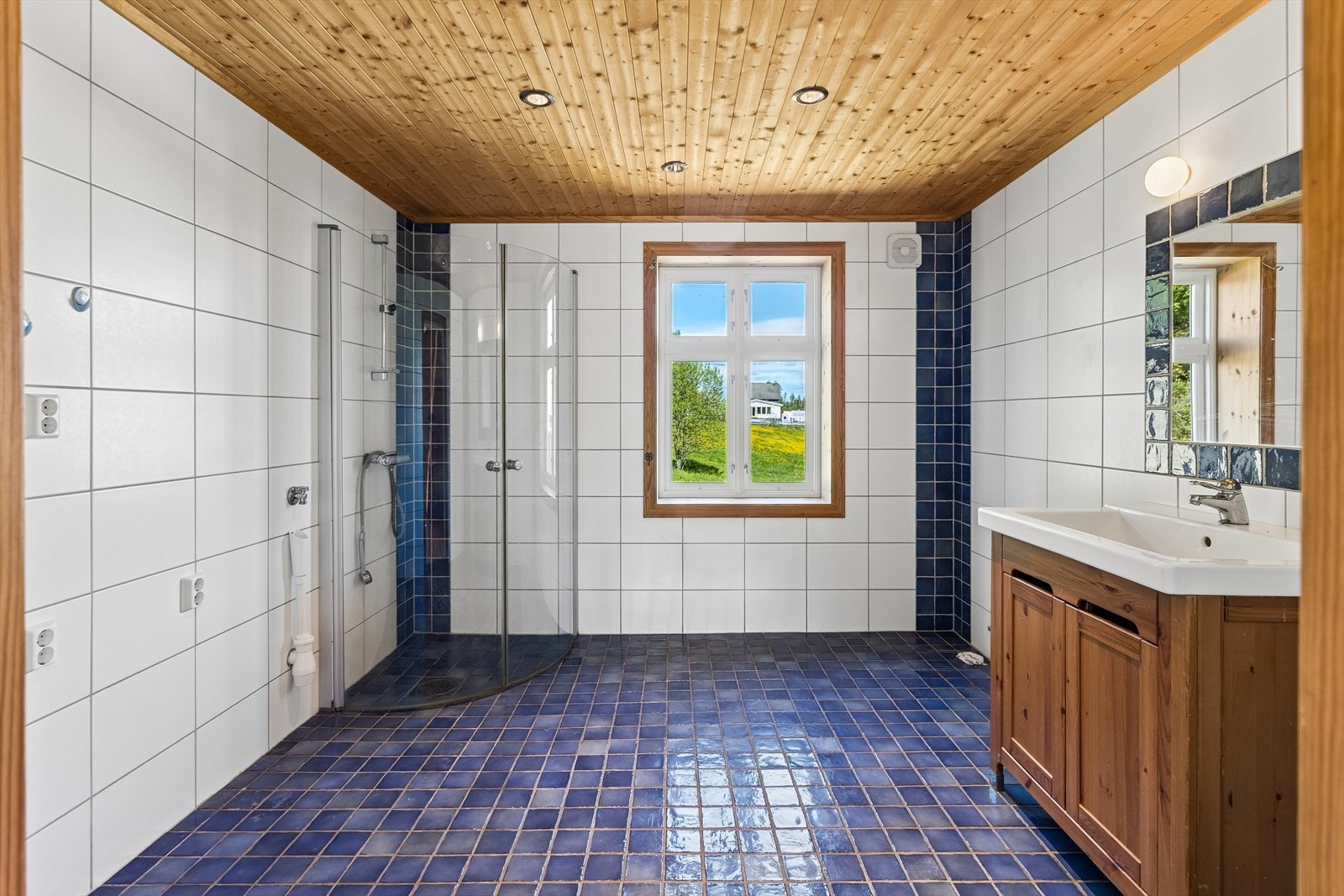 Romslig bad med flislagte overflater, panel i himling og opplegg for vaskemaskin. Badet ble oppgradert i forbindelse med tilbygg rundt 2007. Galleribilde