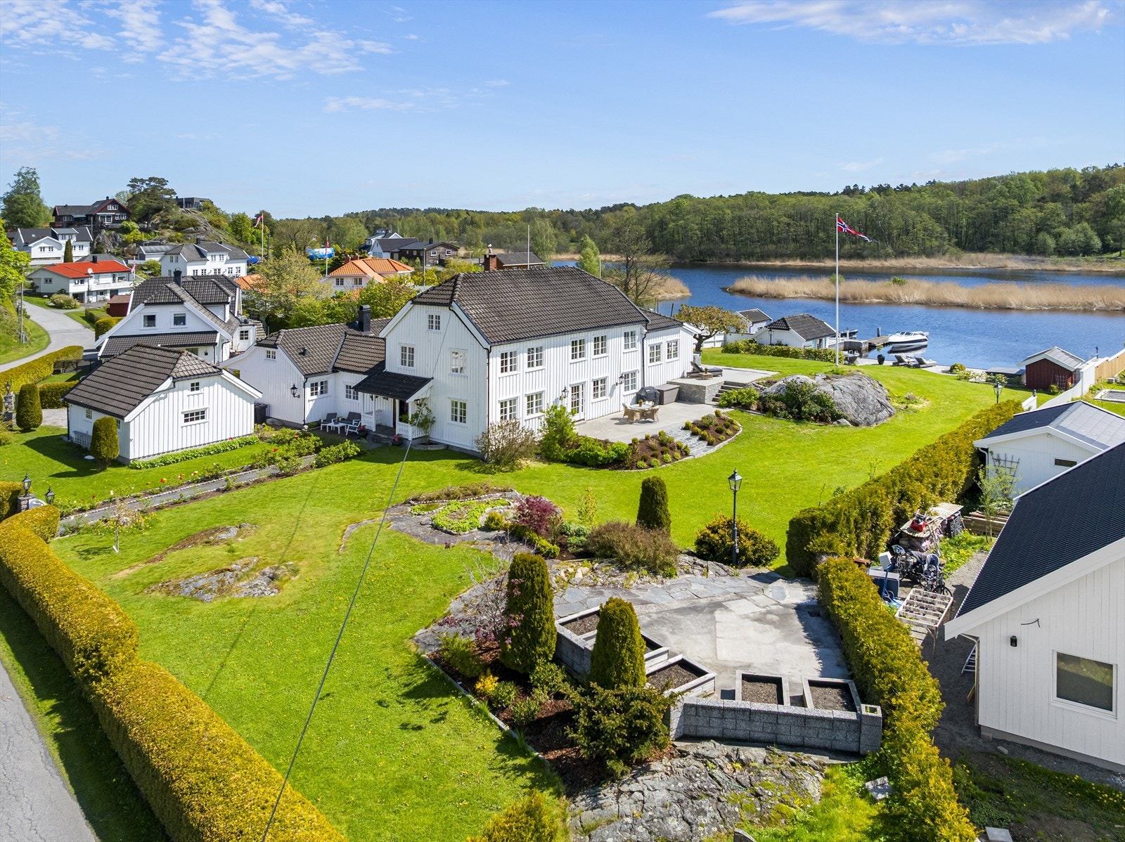 Praktfull hage med innslag av naturbed, belysning, hekker mot gate og gjerde mot nabo. Galleribilde