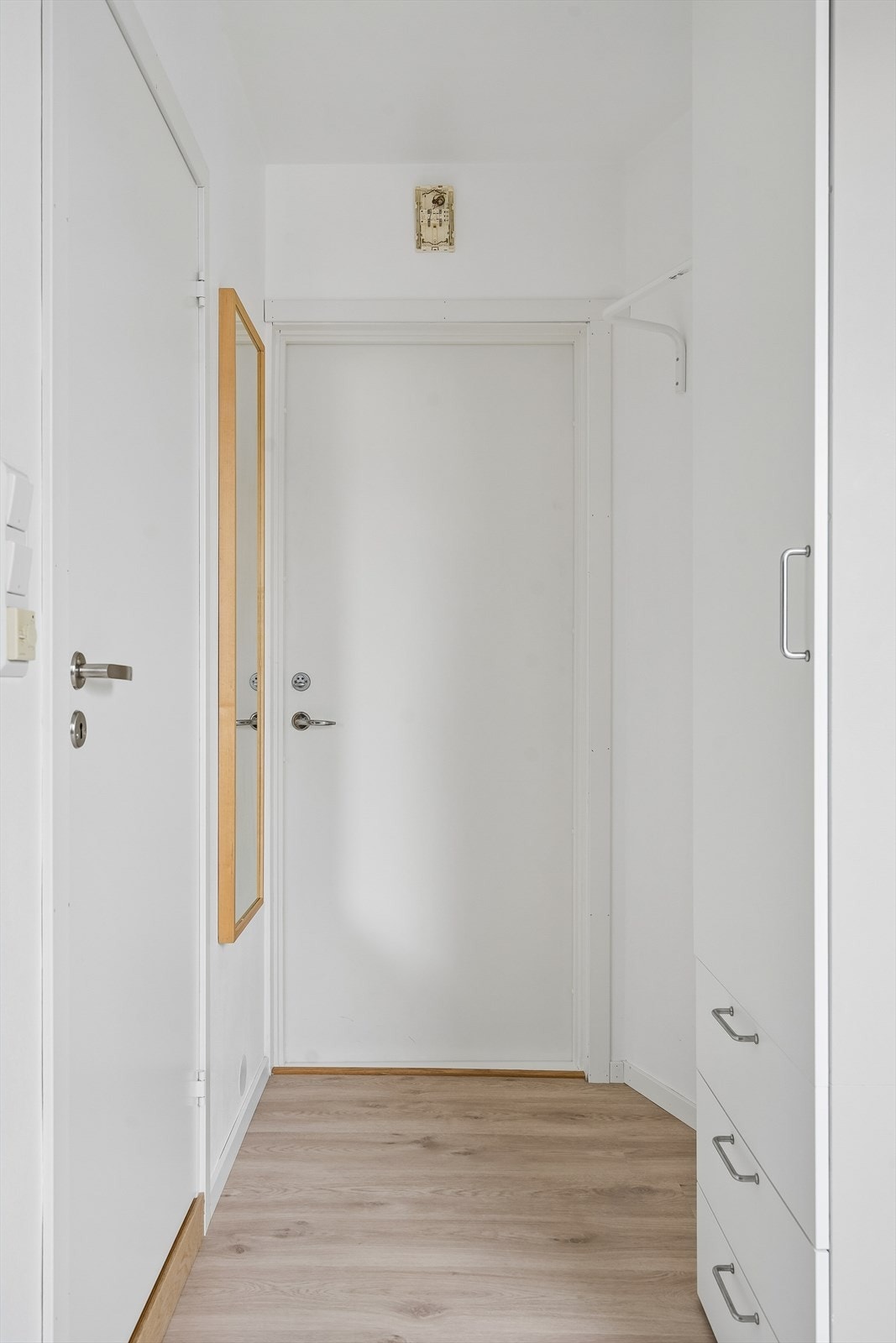 Entré med plass til oppbevaring. Laminatgulvet er gjennomgående i oppholdsrommet. Galleribilde