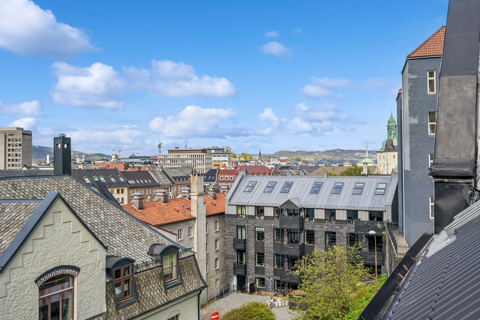Utsikt mot byens tak og omkringliggende bebyggelse. Galleribilde