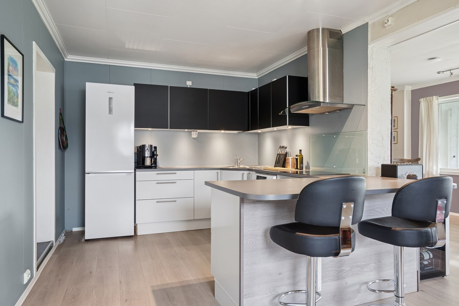 Kjøkkenet har innredning med glatte fronter og benkeplate av slitesterk laminat. Galleribilde