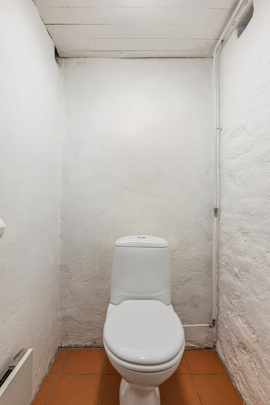 Separat toalettrom i underetasjen, med gulvstående klosett og fliser på gulvet. Galleribilde