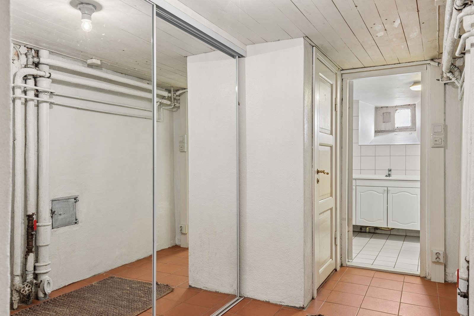 En skyvedørsgarderobe med speilfronter i gangen i underetasjen gir effektiv oppbevaring. Galleribilde