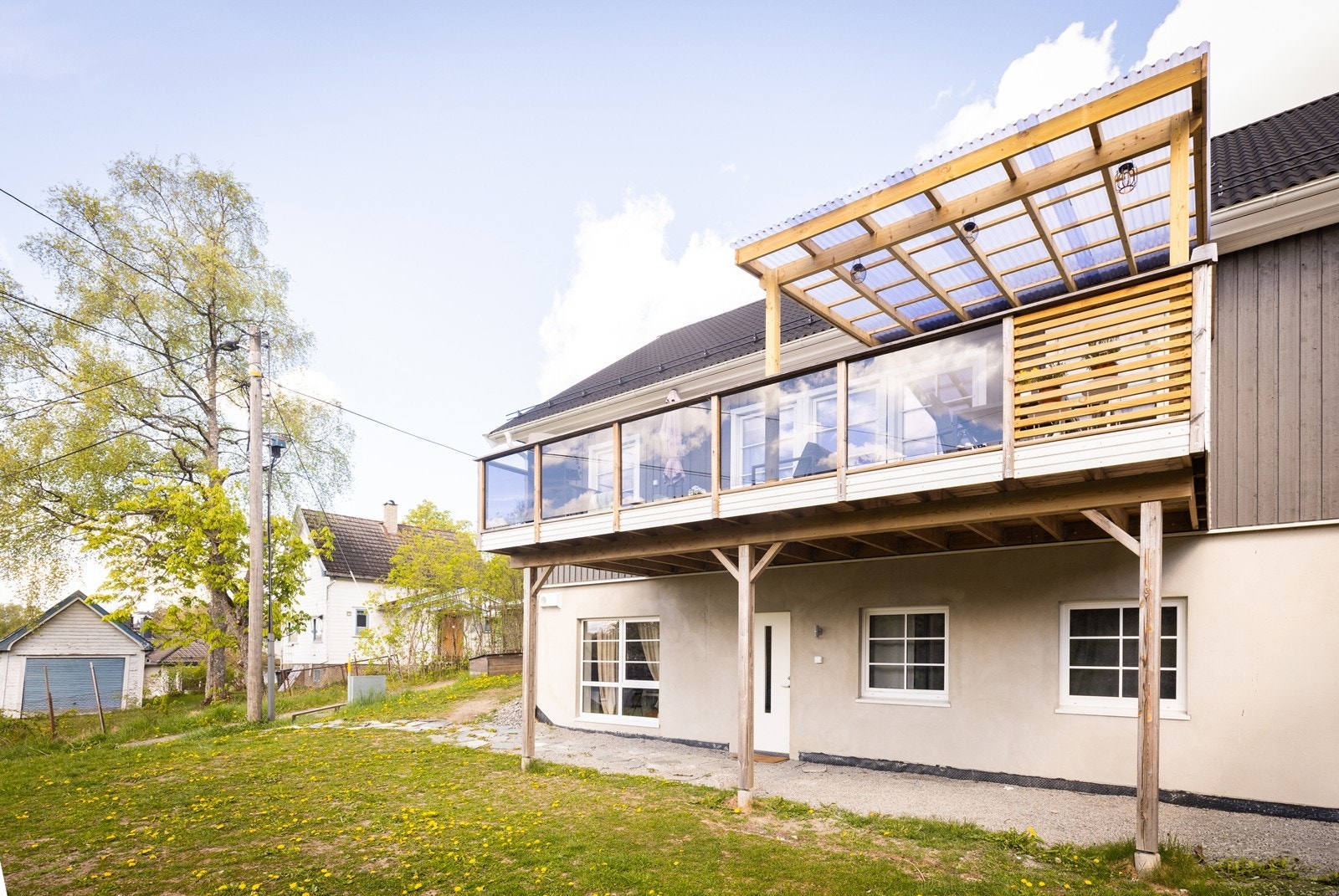 Boligen sett fra baksiden, med verandaen i første etasje og hybelen under. Galleribilde