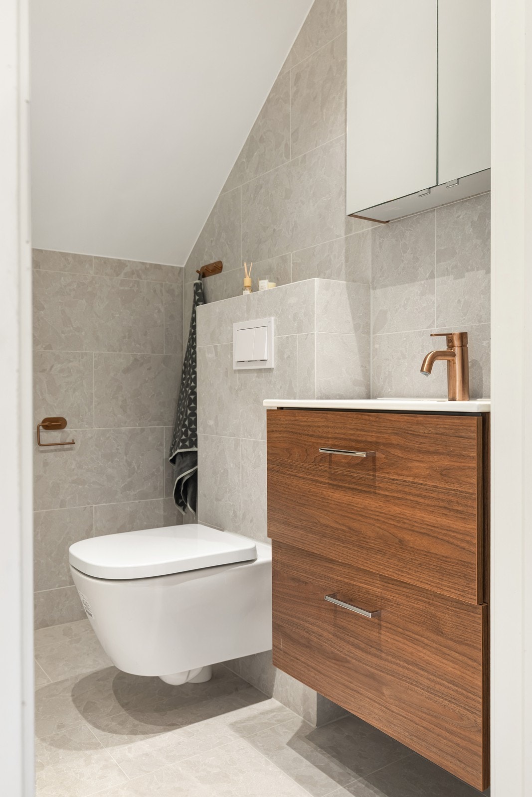 Badet på loft fra 2025 har delikate grå fliser på gulv og vegger, samt gulvvarme. Galleribilde