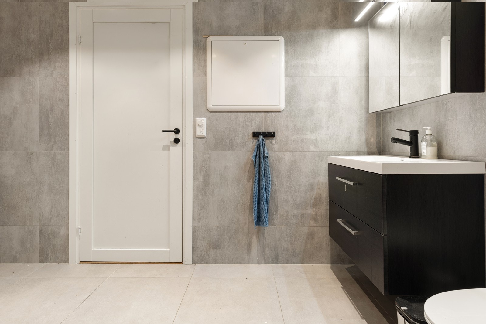 Badet er utstyrt med vegghengt toalett, servantskap og speilskap. Galleribilde