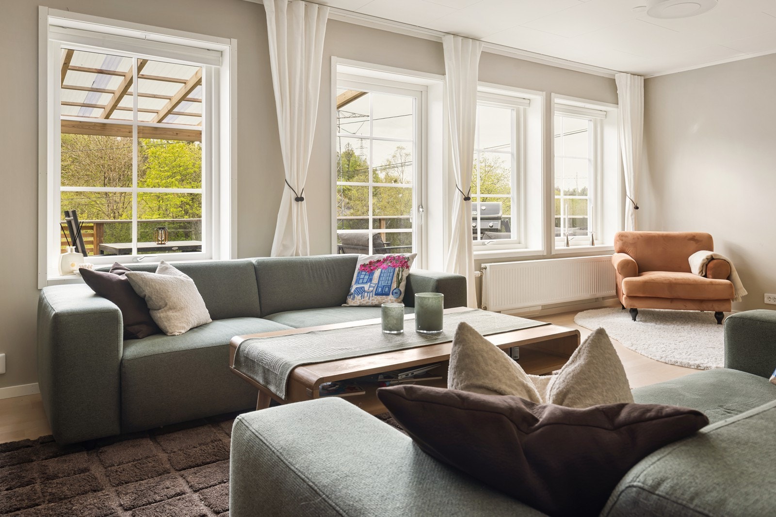 Store vindusflater gir rikelig med naturlig lys i stuen. Galleribilde