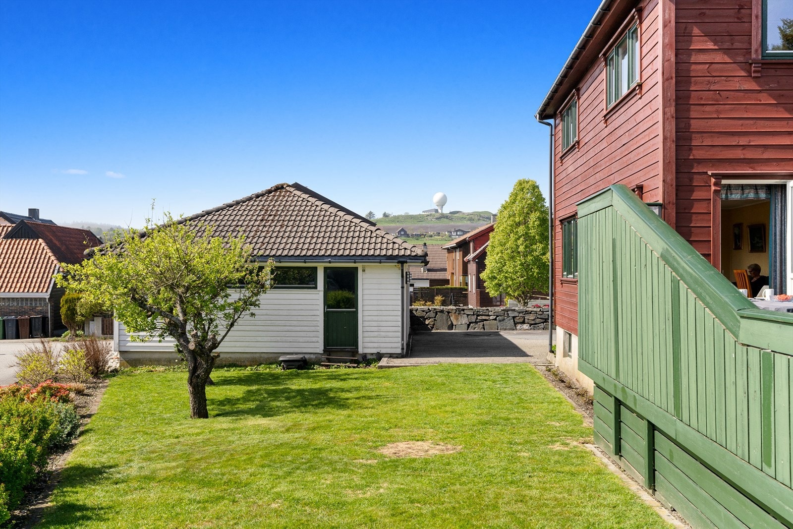 Utsikt fra hagen mot nærområdet og garasjen. Galleribilde