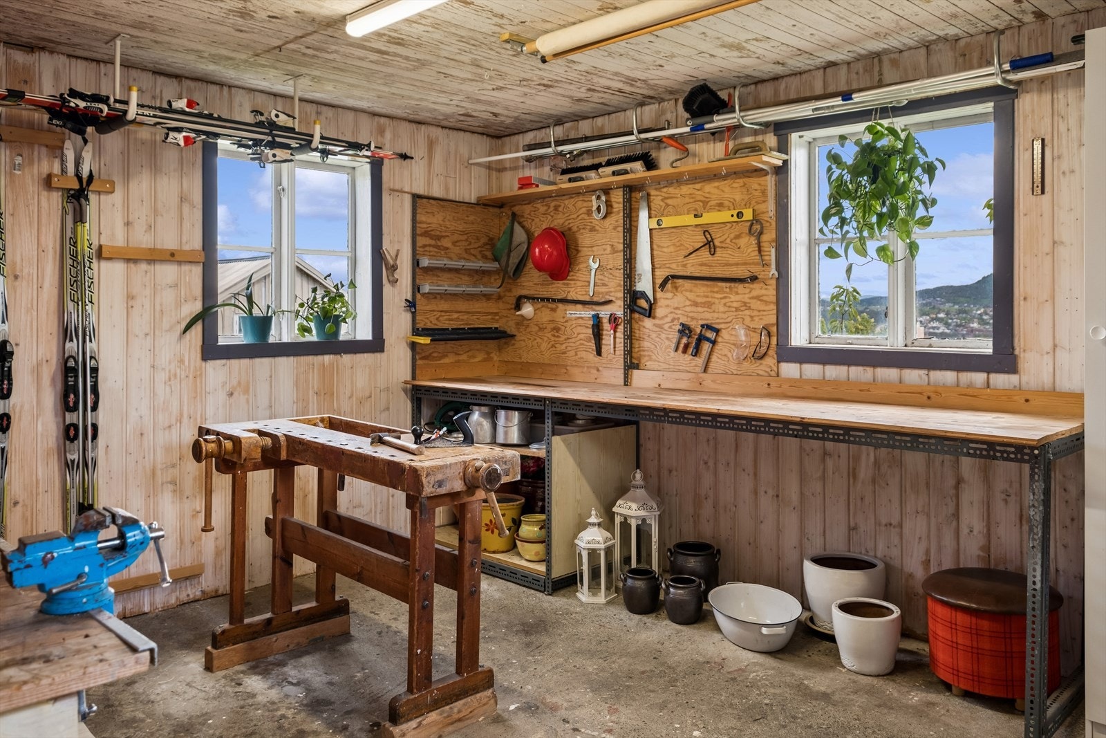 Stor snekkerbod i uthuset med arbeidsbenker og lagringsplass Galleribilde