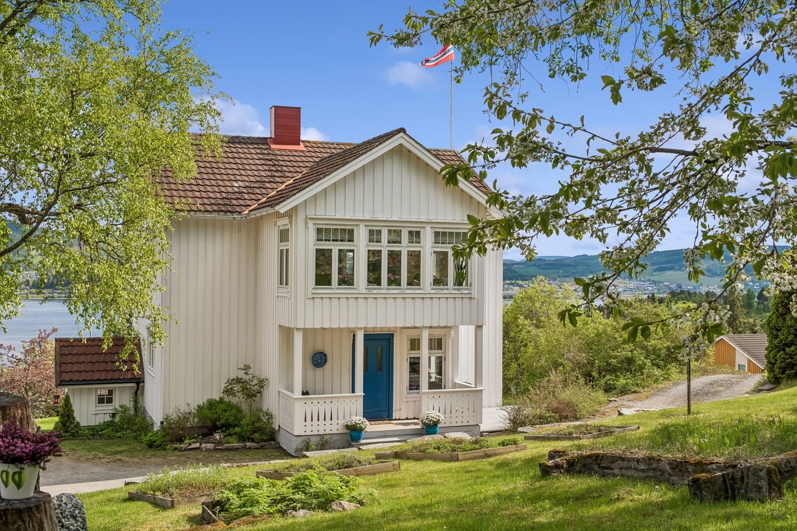 Koselig inngangsparti med sommerstuen over. Frodig og pent opparbeidet hage Galleribilde