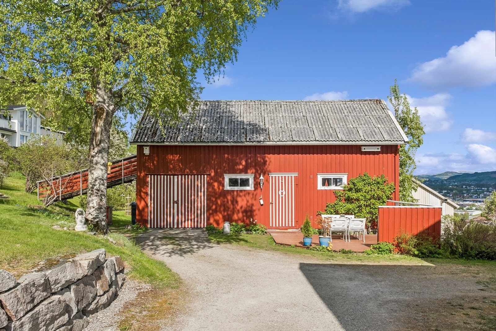 Stort uthus med garasje , snekkerbod, vedbod og låve med stor lagringsplass. Gårdsplassen har plass til flere biler Galleribilde