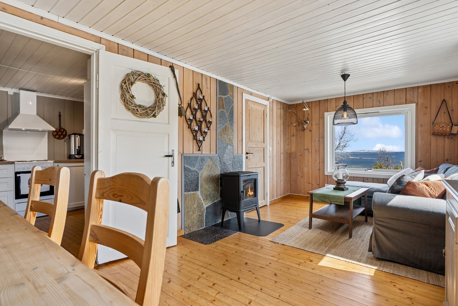 Stuen har plass til både sofagruppe og spisebord, og har vinduer som vender ut mot naturen. Galleribilde