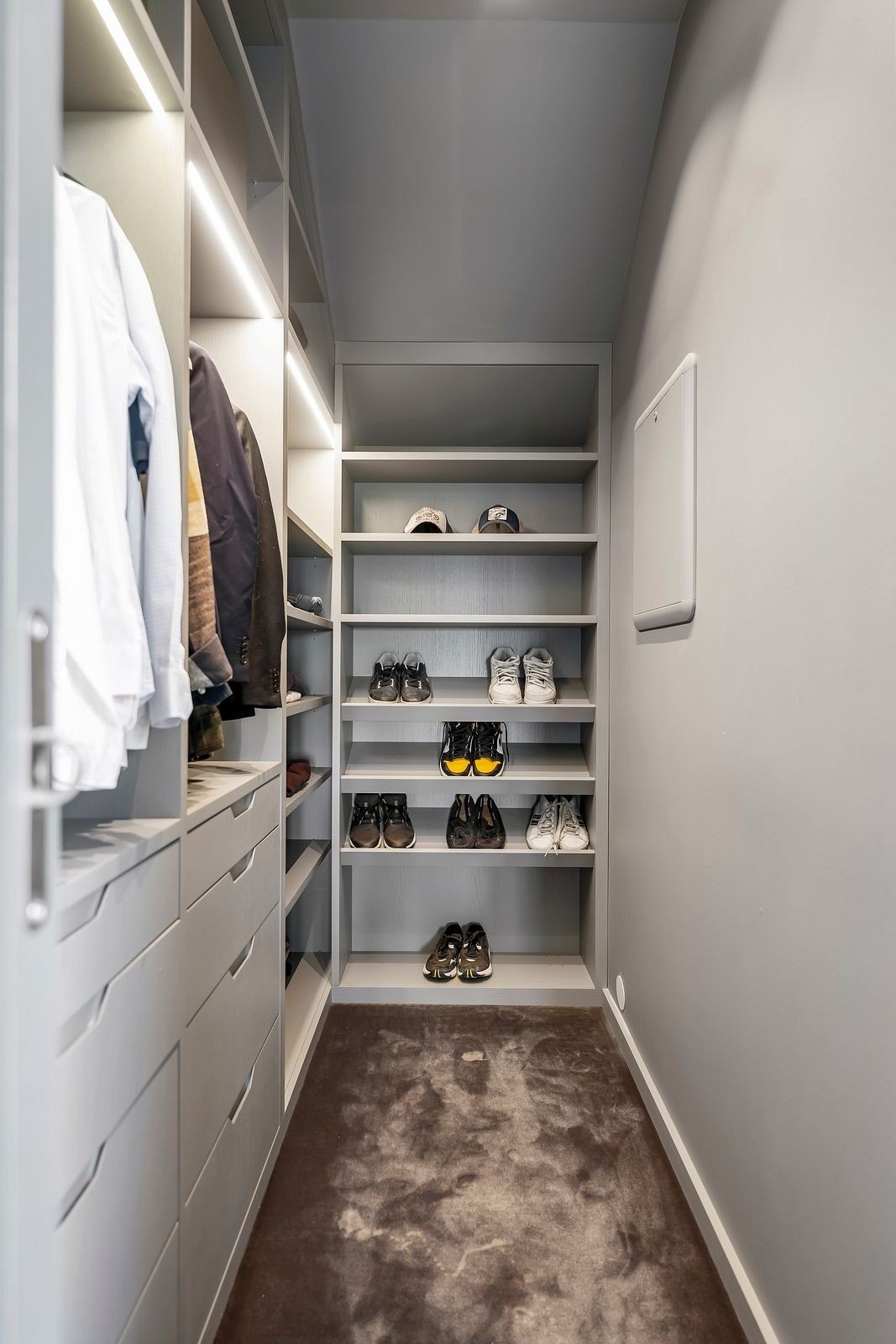 Walk-in-closet på det andre master soverommet med plassbygget og lyssatt innredning. Galleribilde