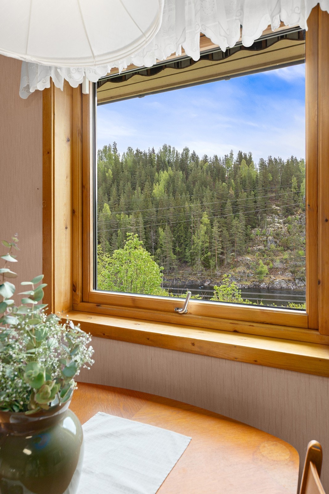 Fra vinduene har man utsikt mot skogkledde åser og landlige omgivelser. Galleribilde
