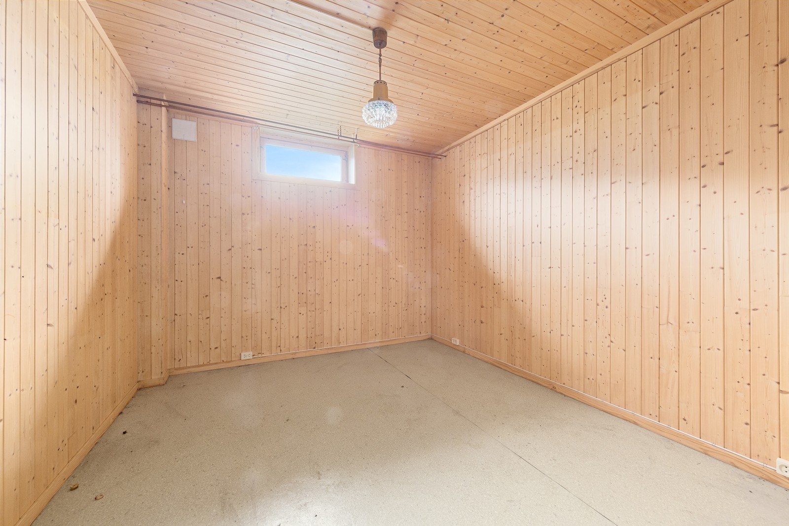 Et av rommene i kjelleren er innredet med panel på vegger og tak. Galleribilde