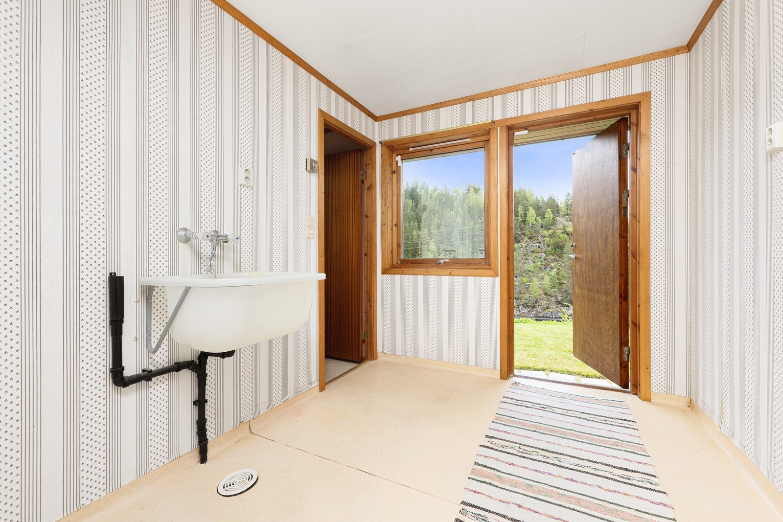 Praktisk rom med egen utgang, innredet for klesvask med sluk i gulvet. Galleribilde