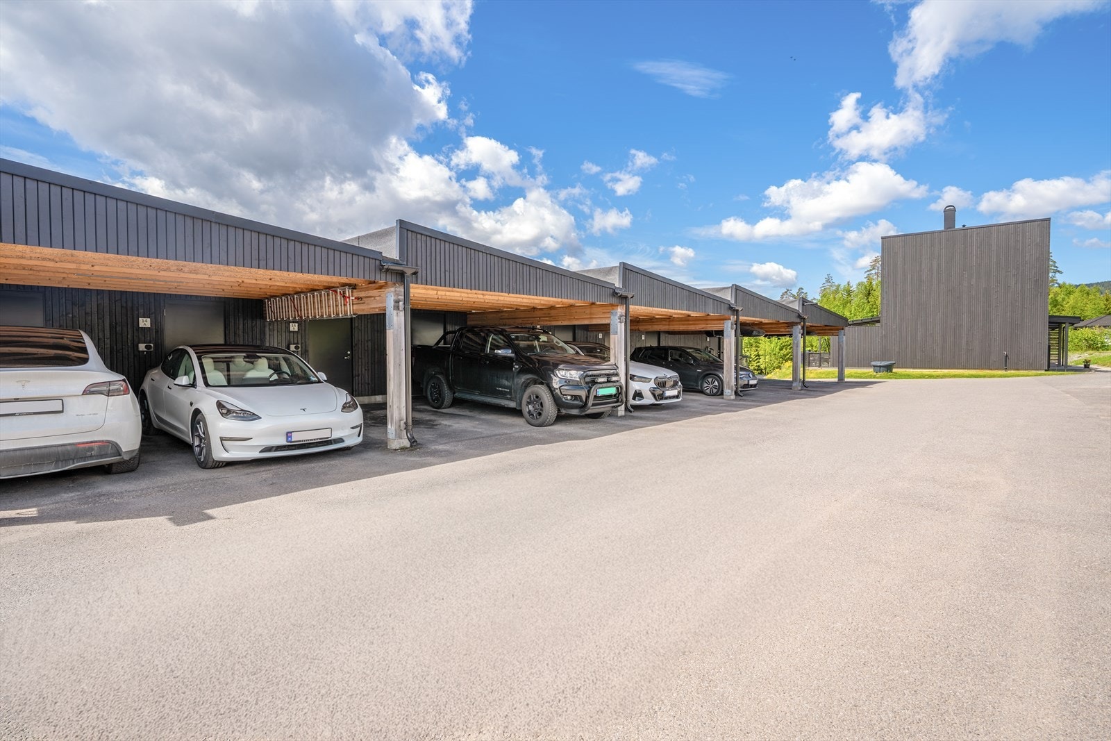Rett ved boligen finner man parkeringsplass i carport med elbil- lader. Galleribilde