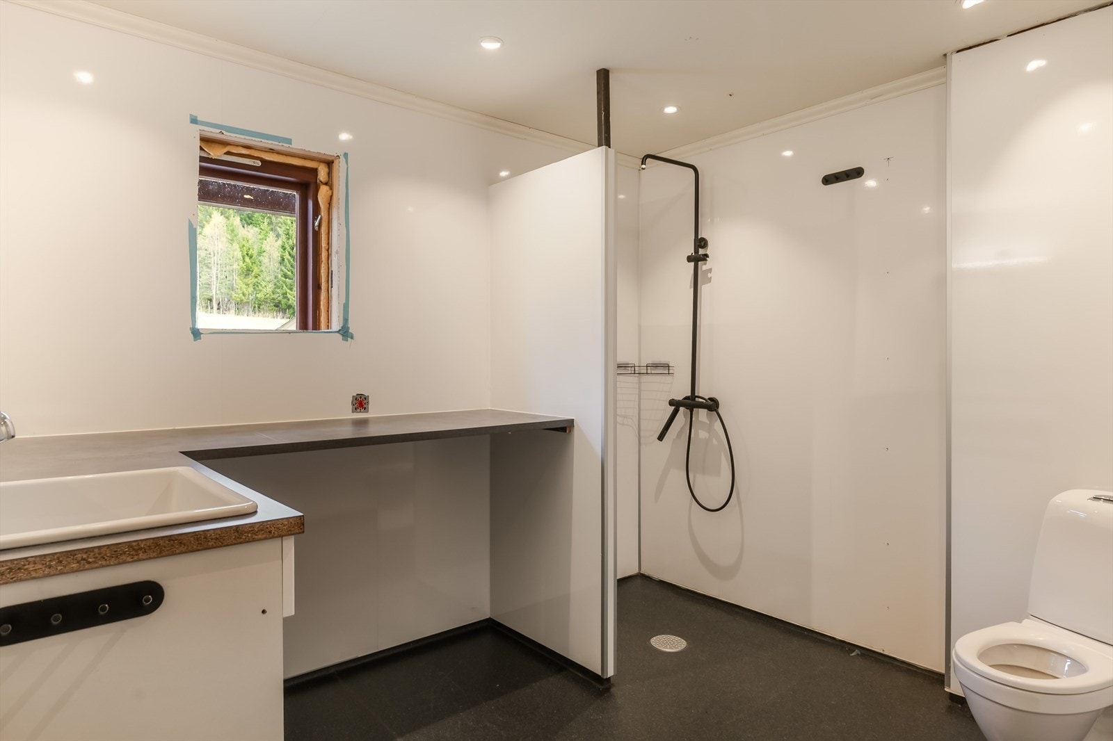 Nyere bad med noe gjenstående arbeider. Baderommet har våtromsbelegg på gulv, lyse våtromsplater på veggene, downlights i himlingen og elektrisk styrt vifte. Galleribilde