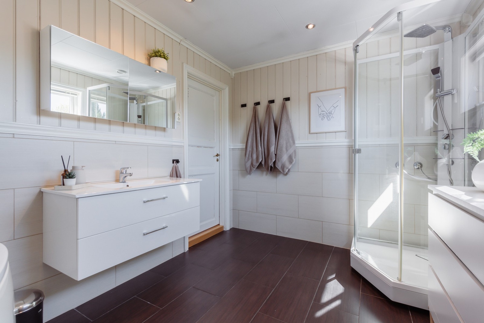 På badet er det både et dusjkabinett med regnfallsdusj og et hjørnebadekar med dusjløsning. Varme er lagt i gulvet, og badet har toalett og downlights. Galleribilde