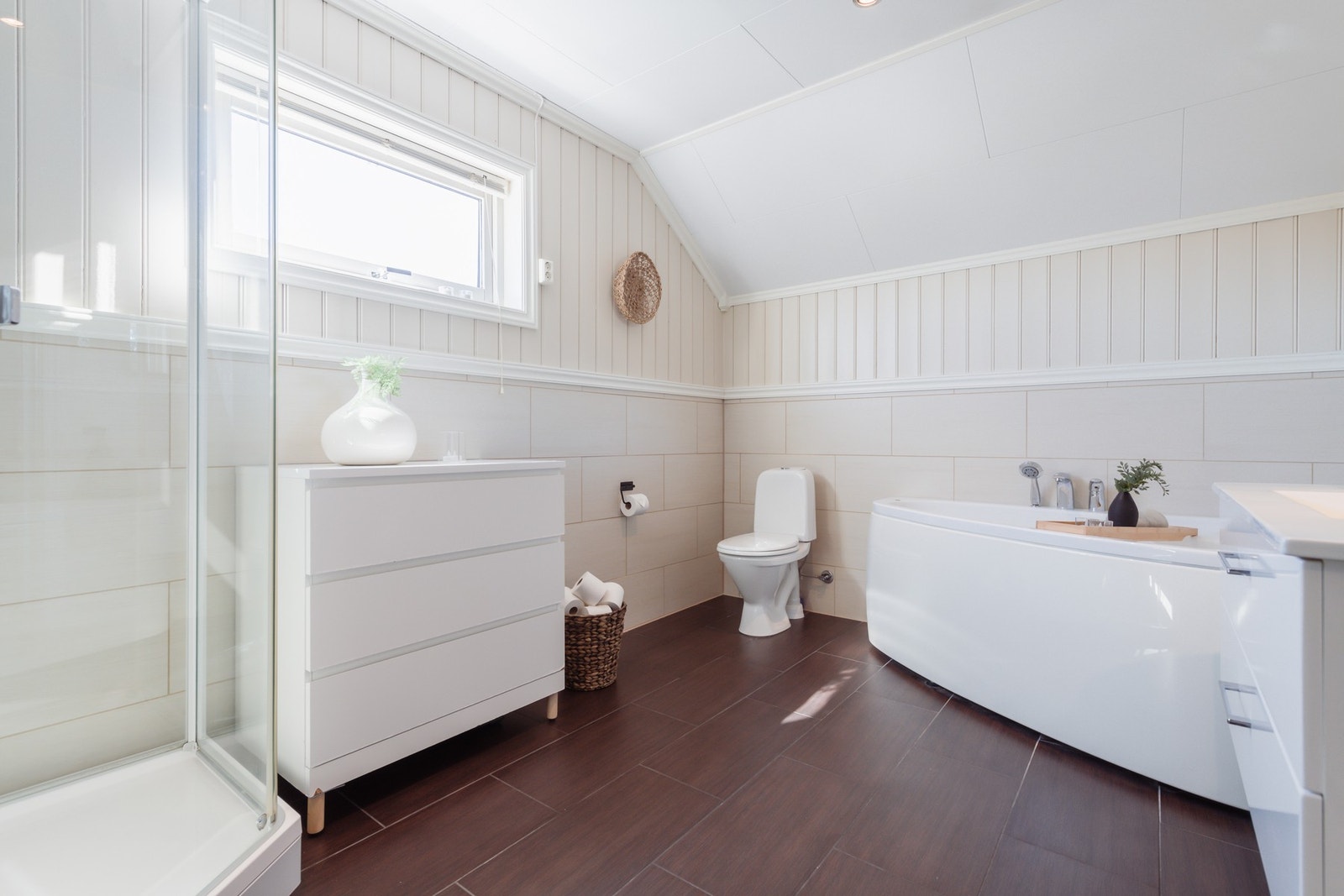 Badet ligger utenfor soverommene. Store, mørke gulvfliser kombineres med store, duse veggfliser i brystningshøyde. Galleribilde