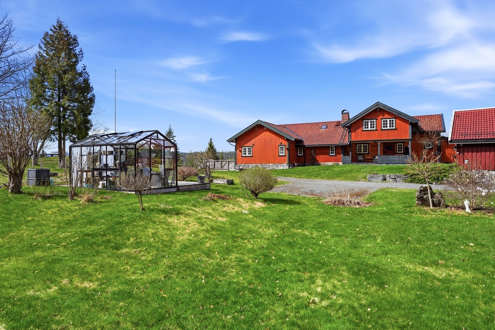 Tomten er opparbeidet med gressplen, gruset gårdsplass og diverse beplantning. Galleribilde