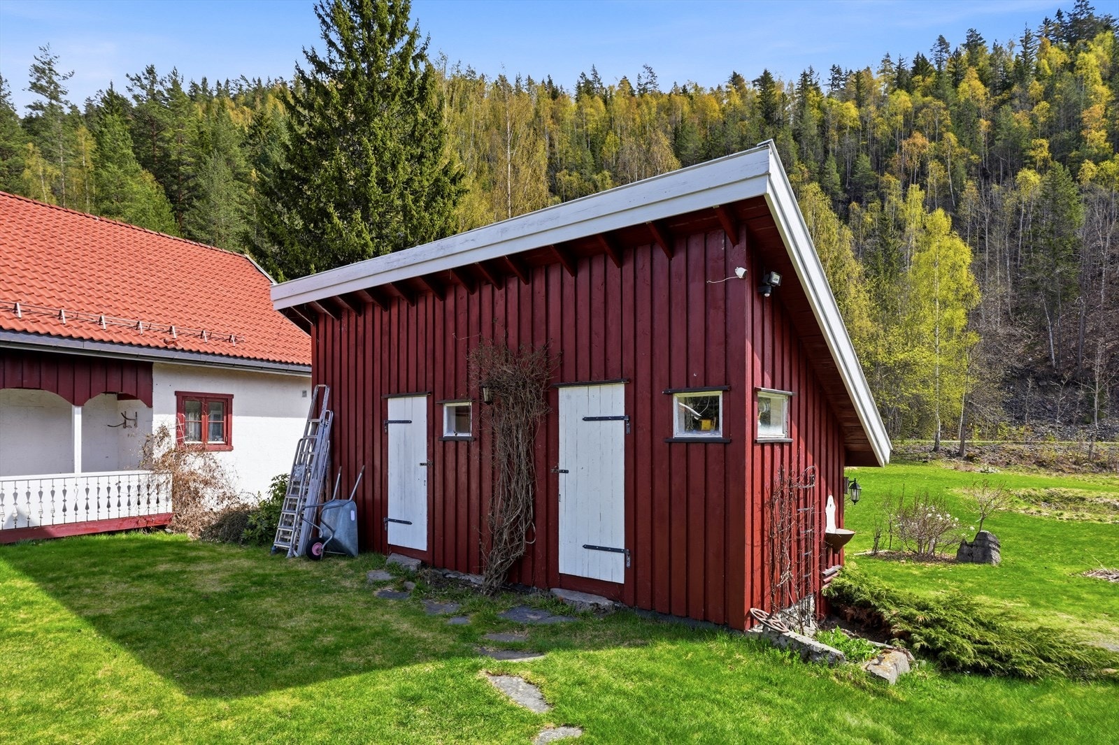 En separat bod på 15 m² gir ekstra lagringsplass på eiendommen. Galleribilde