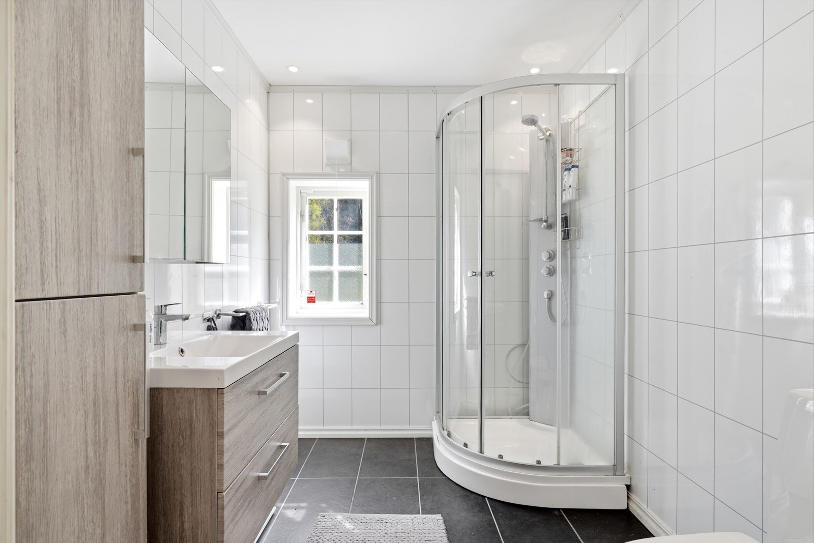 Badet tilknyttet soverommet ble etablert i 2016, og har fliser på gulv og baderomsplater på veggene. Galleribilde