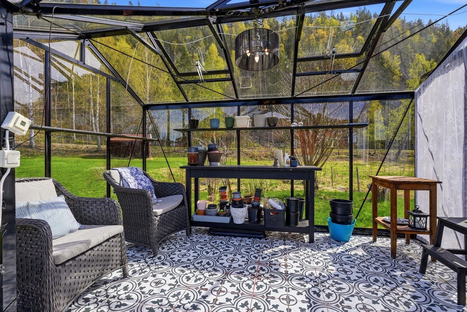 Inne i drivhuset er det god plass til både planter og en koselig, liten sittegruppe. Galleribilde